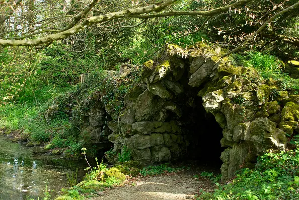 Grotto and pond in the listed park of Château d’Attre, Exceptional Garden of Wallonia, Belgium